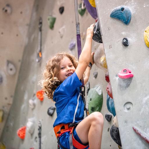 EIn Mädchen klettert in einer Kletterhalle