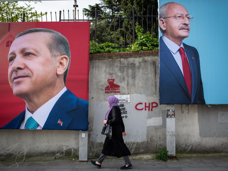 An einer Straße in Istanbul hängen große Werbeplakate von Langzeitpräsident Erdogan und Herausforderte Kemal Kilicdaroglu. Eine Frau geht an den Plakaten entlang. 