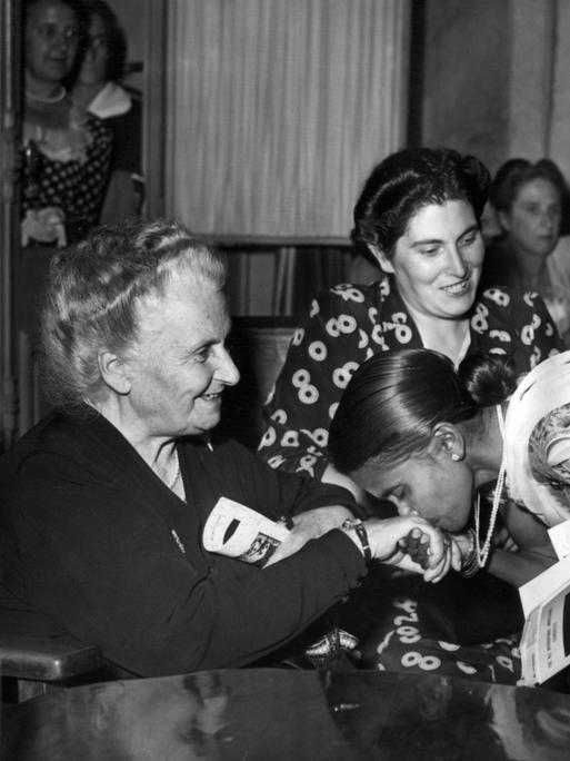 Die italienische Pädagogin und Ãrztin Maria Montessori wird während des 8. Internationalen Montessori-Kongresses am 22. August 1949 in San Remo in Italien von der indischen Delegation ehrfurchtsvoll mit Handkuss begrüßt. 