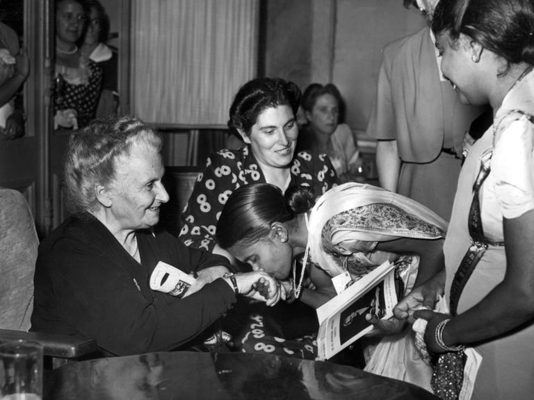 Die italienische Pädagogin und Ãrztin Maria Montessori wird während des 8. Internationalen Montessori-Kongresses am 22. August 1949 in San Remo in Italien von der indischen Delegation ehrfurchtsvoll mit Handkuss begrüßt. 