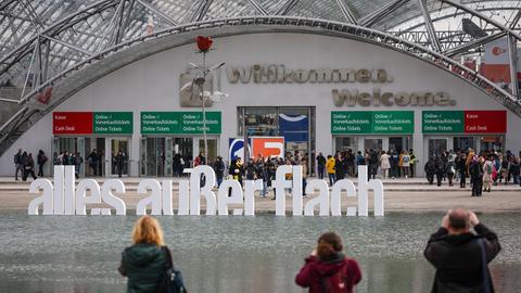 Besucher fotografieren den Schriftzug "alles außer flach" vor der Leipziger Buchmesse. Auf dem Frühjahrstreffen der Buchbranche präsentieren sich über 2000 Aussteller aus 40 Ländern mit ihren Neuheiten. Unter dem Motto "alles außer flach" sind in diesem Jahr die Niederlande und Flandern als Gastland vertreten.
