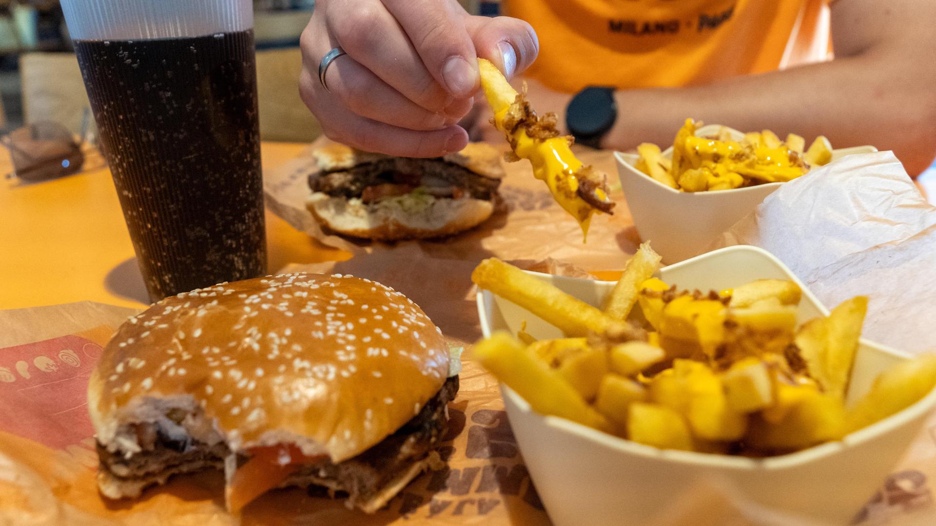 Ein vegetarischer Whopper mit Käsepommes und Softdrink in der Fast Food Systemgastronomie.
