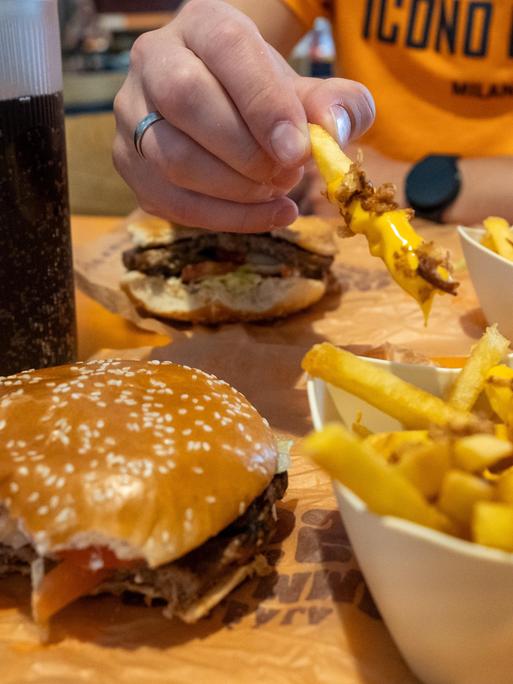 Ein vegetarischer Whopper mit Käsepommes und Softdrink in der Fast Food Systemgastronomie.