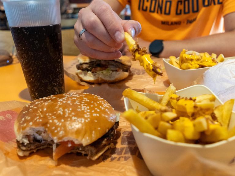 Ein vegetarischer Whopper mit Käsepommes und Softdrink in der Fast Food Systemgastronomie.