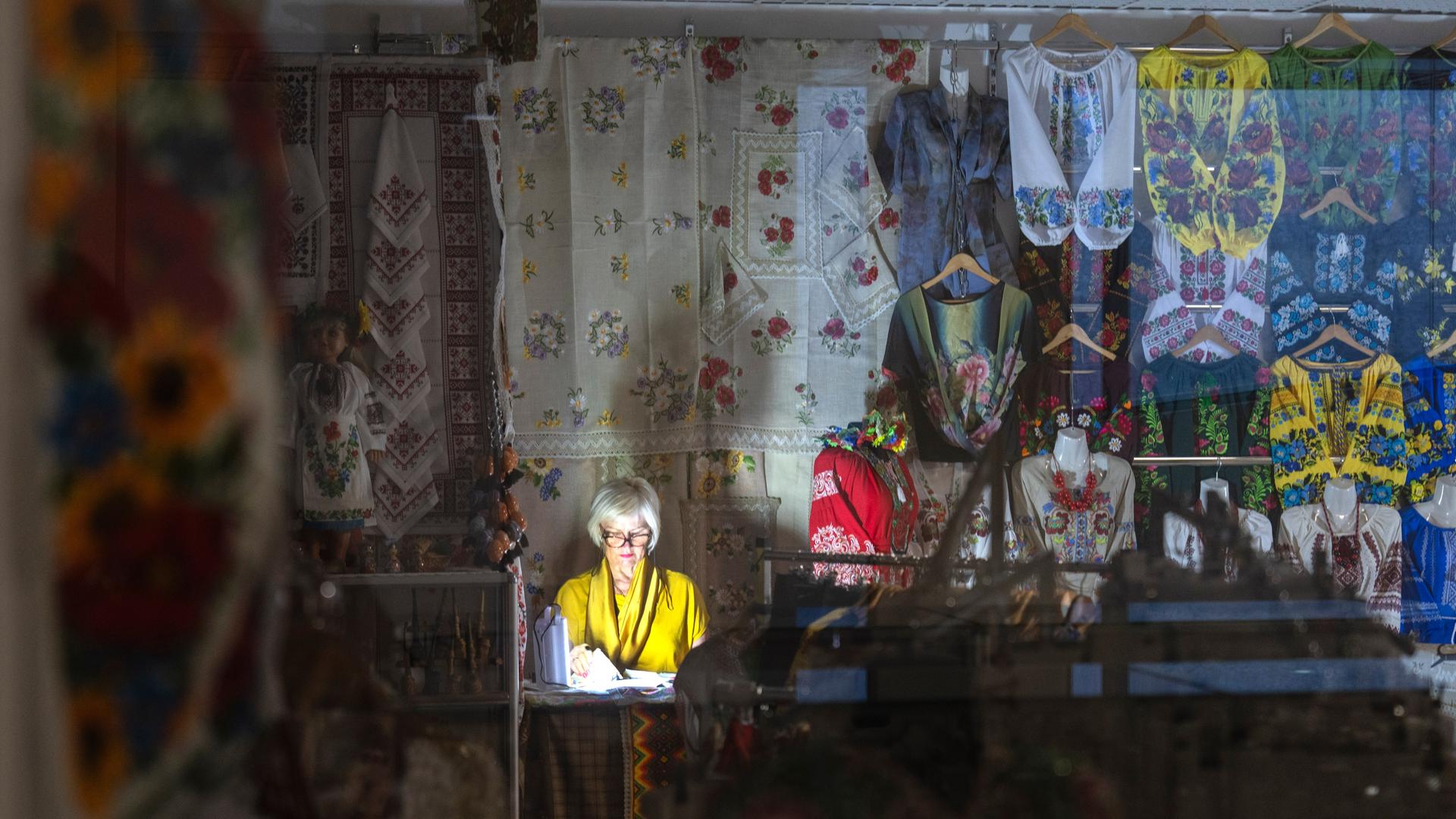 Ukraine, Kiew: Eine Verkäuferin arbeitet mit dem Licht einer Taschenlampe bei einem Stromausfall in einem unterirdischen Einkaufszentrum. Ukraine, Kiew: Eine Verkäuferin arbeitet mit dem Licht einer Taschenlampe bei einem Stromausfall in einem unterirdischen Einkaufszentrum.
