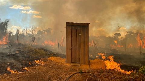 Ein Toilettenhäuschen in Flammen.
