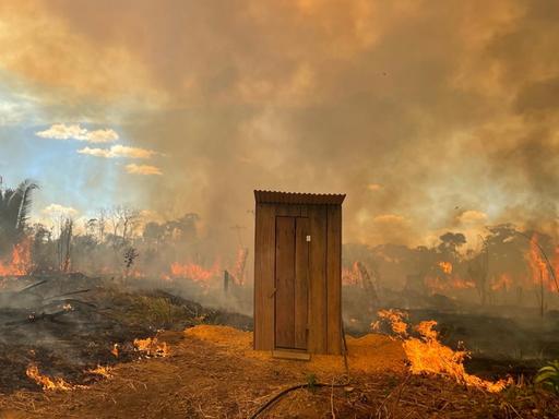 Ein Toilettenhäuschen in Flammen.