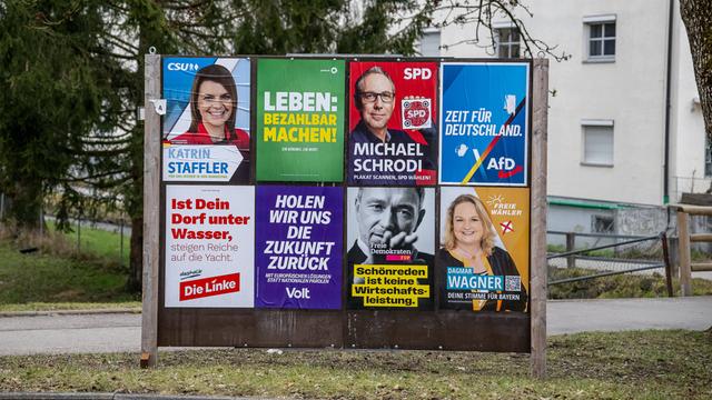 Eine Wand mit verschiedenen Wahlplakaten.