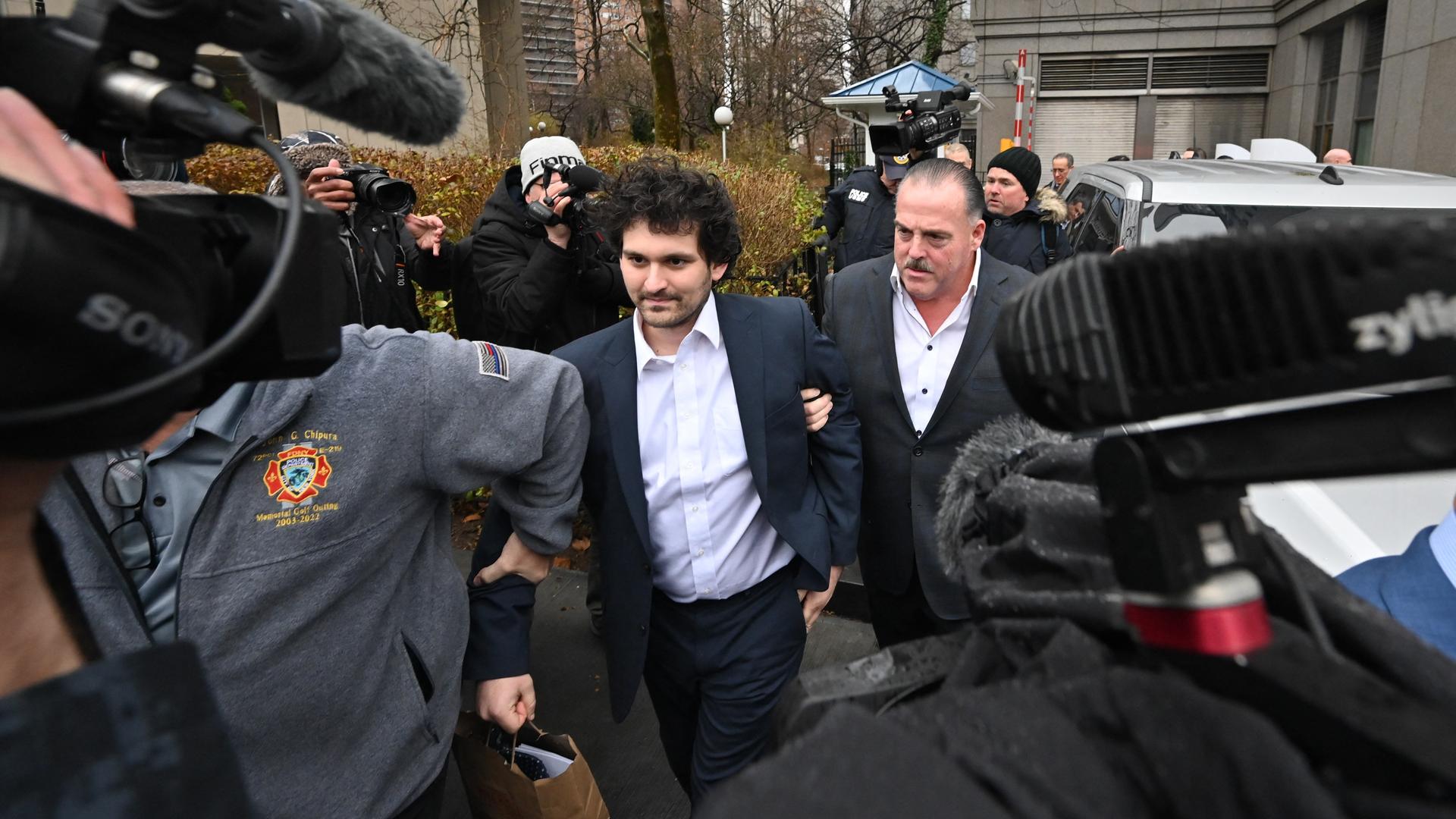 Das Foto zeigt den FTX-Gründer Sam Bankman-Fried mitten in einer Menschenmenge. Er verlässt das Gerichtsgebäude in New York City.