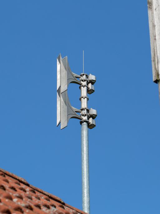 Auf einem Mast auf einem Dach ist eine Sirene montiert. 