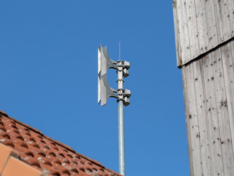 Auf einem Mast auf einem Dach ist eine Sirene montiert. 