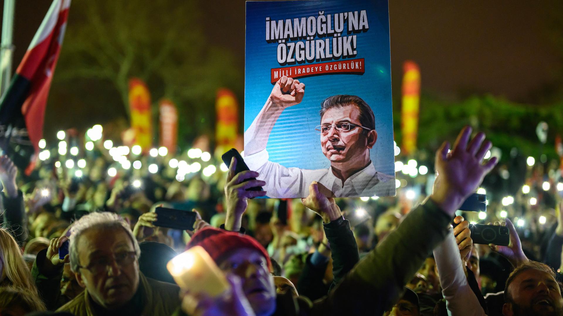 Demonstranten halten bei einem Protest ein Poster von Ekrem Imamoğlu in die Höhe. Demonstranten halten bei einem Protest ein Poster von Ekrem Imamoğlu in die Höhe.