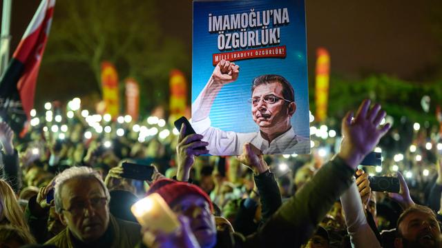 Demonstranten halten bei einem Protest ein Poster von Ekrem Imamoğlu in die Höhe.