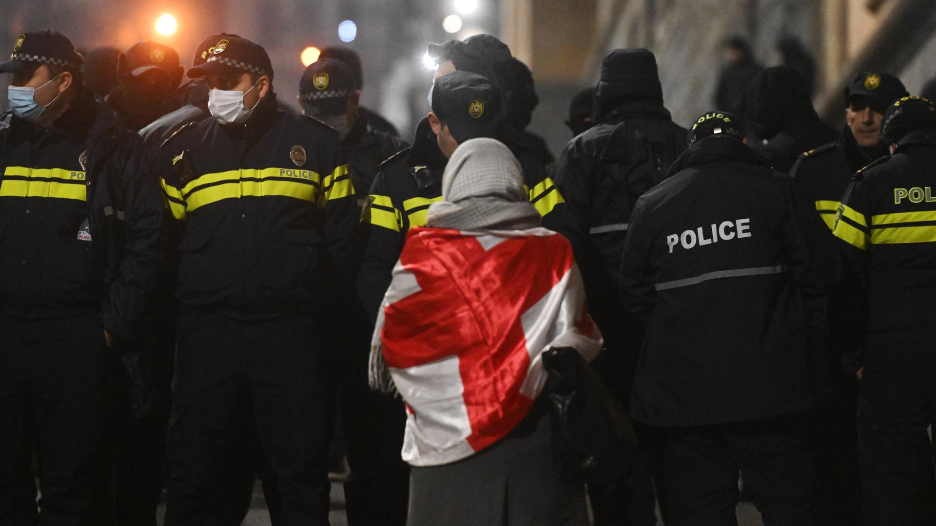 Eine pro-europäische Demonstrantin steht vor einer Gruppe Polizisten bei einer Demo im Winter 2024 in Tiflis, Georgien. Eine pro-europäische Demonstrantin steht vor einer Gruppe Polizisten bei einer Demo im Winter 2024 in Tiflis, Georgien.