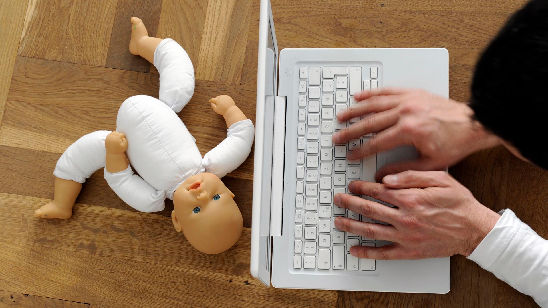 Symbolfoto zum Thema Kindesmissbrauch und Internetpornografie: Die Hände eines Mannes an einer Tastatur, daneben eine zerbrochene Kinderpuppe. 