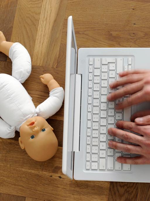 Symbolfoto zum Thema Kindesmissbrauch und Internetpornografie: Die Hände eines Mannes an einer Tastatur, daneben eine zerbrochene Kinderpuppe. 
