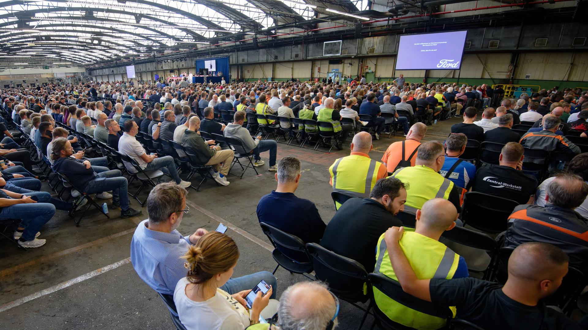 Mitarbeiter warten auf den Beginn einer Mitarbeiterversammlung in den Kölner Ford-Werken.