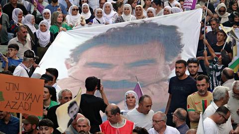 Eine Gruppe kurdischer Frauen trägt während eines Protestmarsches ein Banner des PKK-Führers Abdullah Öcalan. 