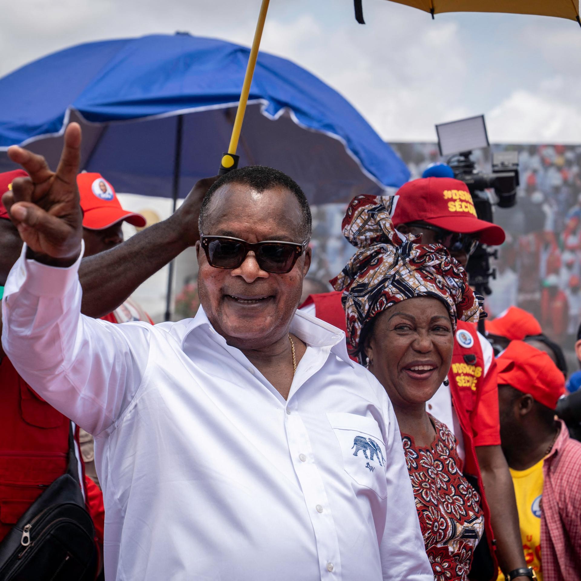 Denis Sassou Nguesso, Präsident der Republik Kongo, grüßt in die Menge und ist von Anhängern während eines Wahlkampfauftritts in der Hafenstadt Pointe-Noire umgeben.
