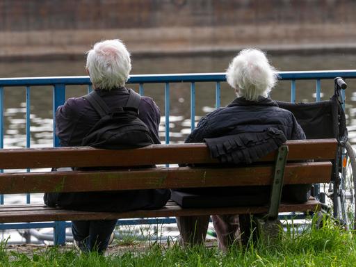 Senioren sitzen auf einer Parkbank am Fluss. Senioren sitzen auf einer Parkbank am Fluss.