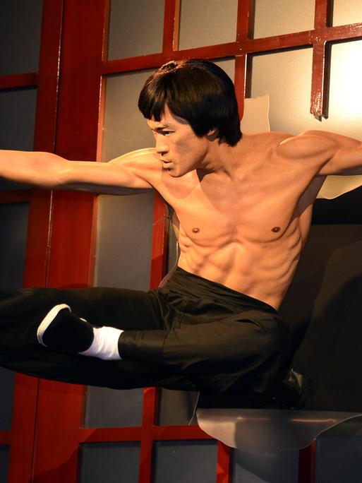 Martial arts Legende und Schauspieler Bruce Lee fliegt durch eine Tür - klassische Actionszene, umgesetzt als Wachsfigur im Madame Tussauds Hollywood Museum in Hollywood, Kalifornien, USA