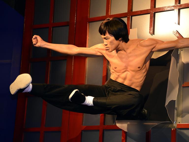 Martial arts Legende und Schauspieler Bruce Lee fliegt durch eine Tür - klassische Actionszene, umgesetzt als Wachsfigur im Madame Tussauds Hollywood Museum in Hollywood, Kalifornien, USA