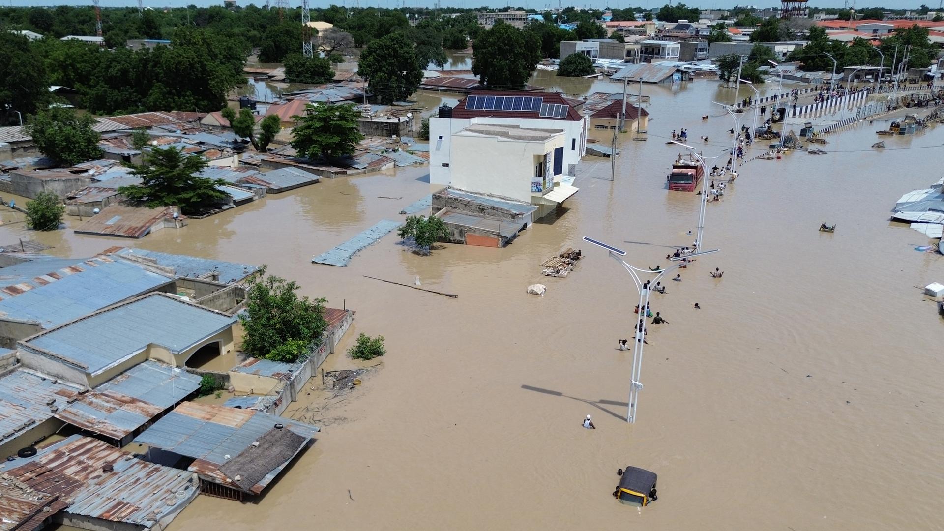 Das Gebeit der Stadt Maiduguri ist überschwemmt. Man sieht nur die Dächer von Häuser, Menschen stehen bis zu Hals im Wasser.