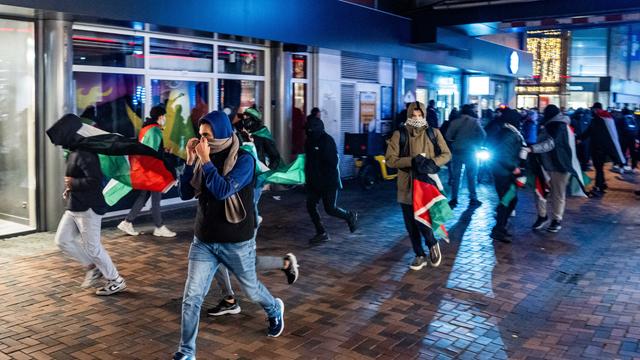 Demonstranten laufen mit palästinensischen Fahnen. Sie sind bei einer pro-palästinensischen Demonstration in Amsterdam.