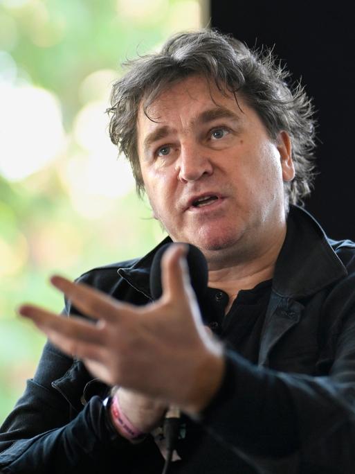 Ilko-Sascha Kowalczuk in schwarzer Kleidung gestekuliert beim Sprechen in ein Mikrofon Ilko-Sascha Kowalczuk in schwarzer Kleidung gestekuliert beim Sprechen in ein Mikrofon