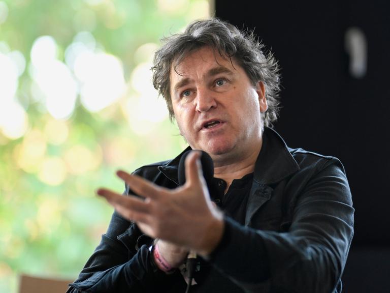 Ilko-Sascha Kowalczuk in schwarzer Kleidung gestekuliert beim Sprechen in ein Mikrofon Ilko-Sascha Kowalczuk in schwarzer Kleidung gestekuliert beim Sprechen in ein Mikrofon