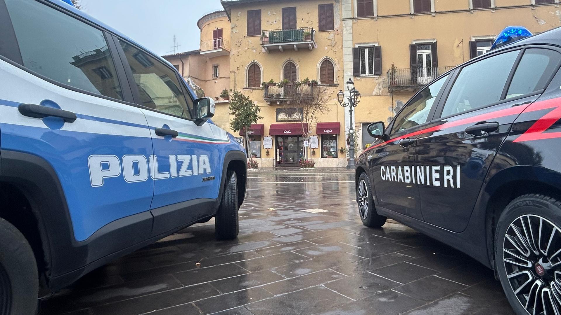 wei Autos der italienischen Polizei und der Carabinieri stehen nebeneinander vor einem Gebäude. 