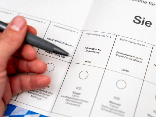 Stimmzettel bei der Briefwahl zur Landtagswahl am 8. Oktober in Bayern. Eine Hand hält einen Kugelschreiber vor dem Wahlfeld für die Partei AfD.