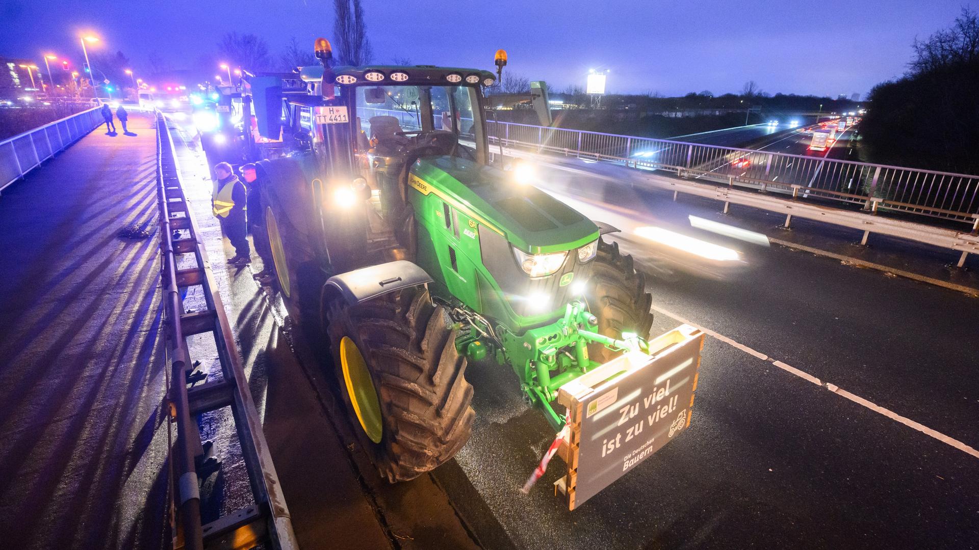 Niedersachsen, Garbsen: Bauern stehen mit Traktoren auf einer Brücke über der Autobahn A2 bei Garbsen in der Region Hannover.