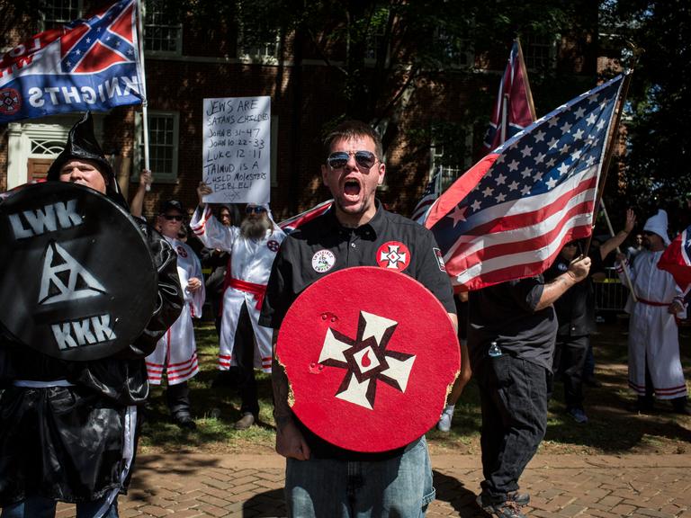 Der Ku-Klux-Klan protestiert am 8. Juli 2017 in Charlottesville, Virginia gegen die geplante Entfernung einer Statue von General Robert E. Lee und fordert den Schutz der Denkmäler der Südstaatenkonföderation. Der Ku-Klux-Klan protestiert am 8. Juli 2017 in Charlottesville, Virginia gegen die geplante Entfernung einer Statue von General Robert E. Lee und fordert den Schutz der Denkmäler der Südstaatenkonföderation.