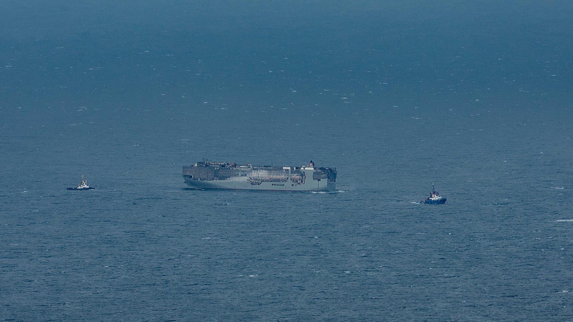 Luftaufnahme des brennenden Frachters Fremantle Highway, der zu einem provisorischen Ankerplatz nördlich von Ameland und Schiermonnikoog geschleppt wird. Luftaufnahme des brennenden Frachters Fremantle Highway, der zu einem provisorischen Ankerplatz nördlich von Ameland und Schiermonnikoog geschleppt wird.