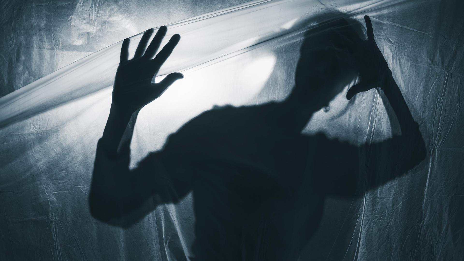 Schatten eines Jugendlichen vor weißgrauem Hintergrund