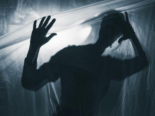 Schatten eines Jugendlichen vor weißgrauem Hintergrund