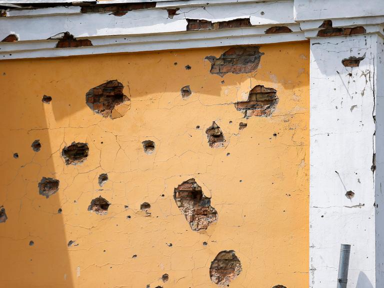 Die zerschossene Wand eines historischen Gebäudes in der Ukraine.