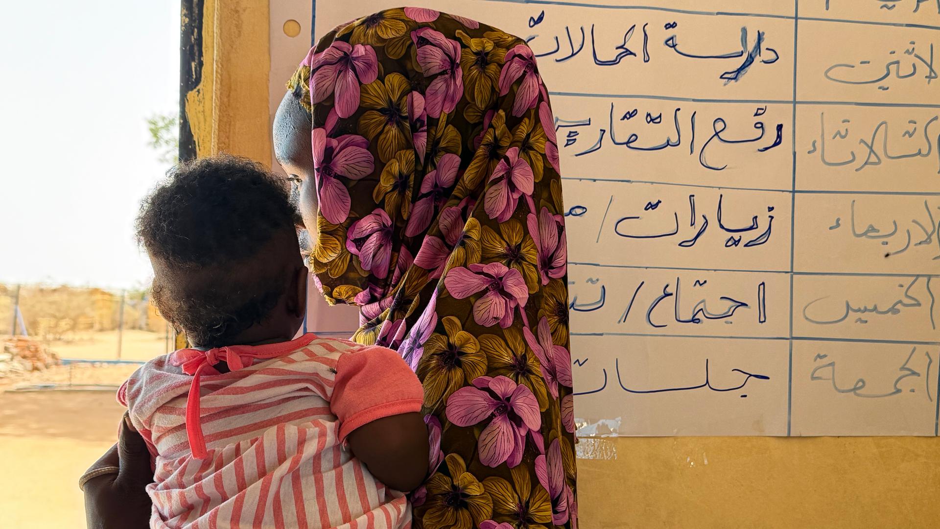 Eine aus dem Sudan geflüchtete Frau hält im Flüchtlingslager Aboutengé im Osten des Tschad ihr Kind auf dem Arm. Eine aus dem Sudan geflüchtete Frau hält im Flüchtlingslager Aboutengé im Osten des Tschad ihr Kind auf dem Arm.