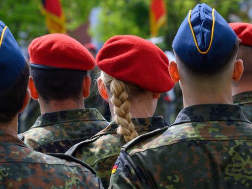 Soldatinnen und Soldaten der Bundeswehr stehen im Goethepark in Burg in Sachsen-Anhalt, fotografiert von hinten.
