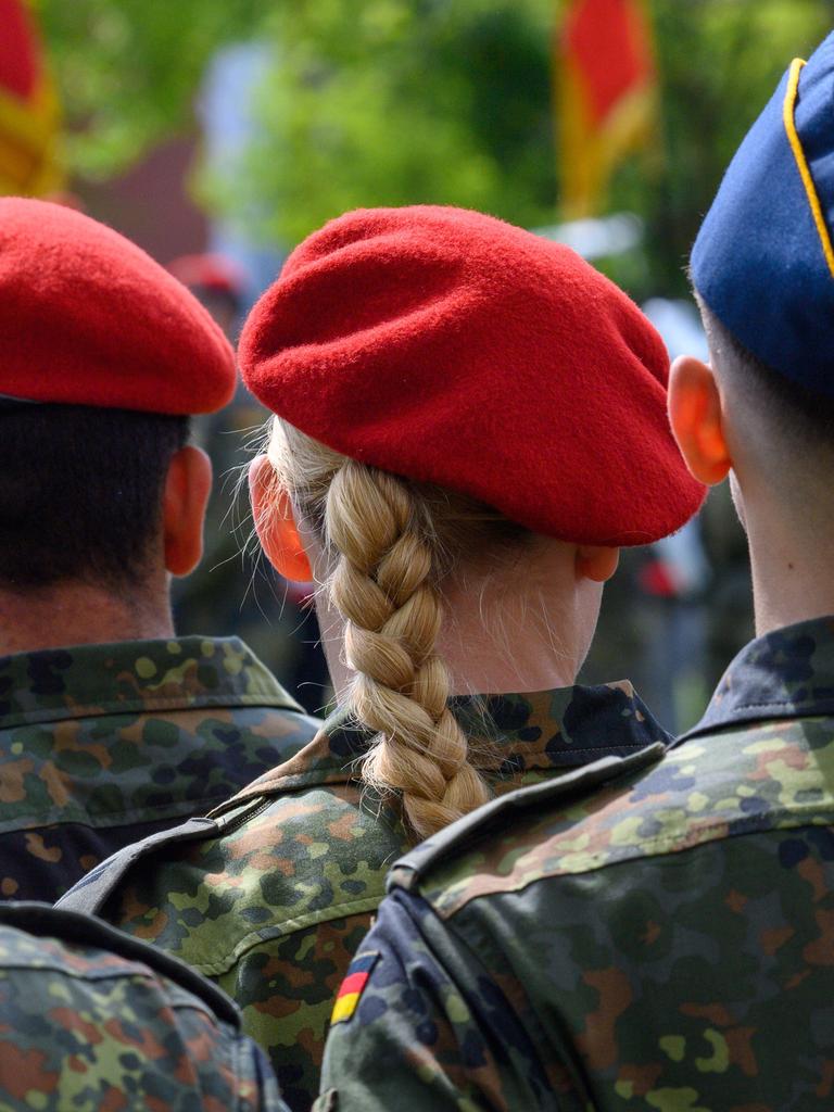 Soldatinnen und Soldaten der Bundeswehr stehen im Goethepark in Burg in Sachsen-Anhalt, fotografiert von hinten.