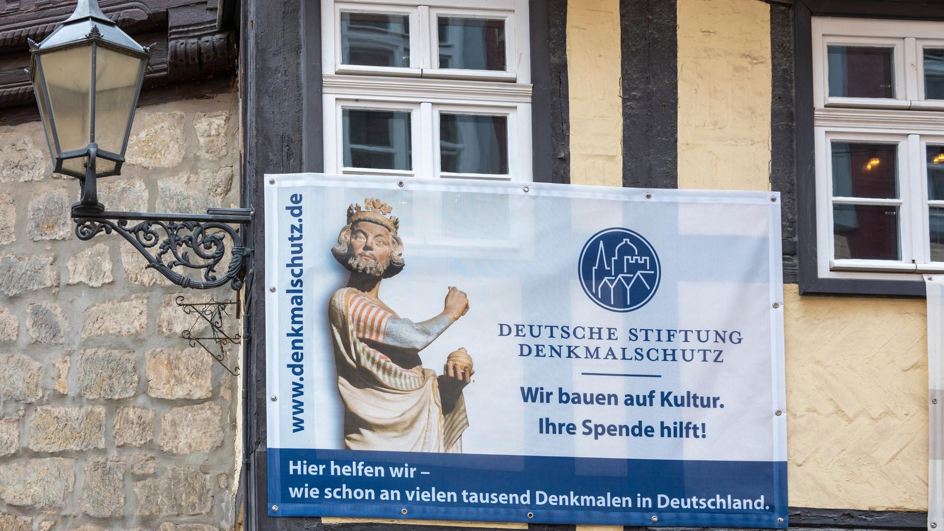 An einem historischen Fachwerkhaus hängt ein Transparent mit der Aufschrift „Deutsche Stiftung Denkmalschutz. Wir bauen auf Kultur. Ihre Spende hilft!“ An einem historischen Fachwerkhaus hängt ein Transparent mit der Aufschrift „Deutsche Stiftung Denkmalschutz. Wir bauen auf Kultur. Ihre Spende hilft!“