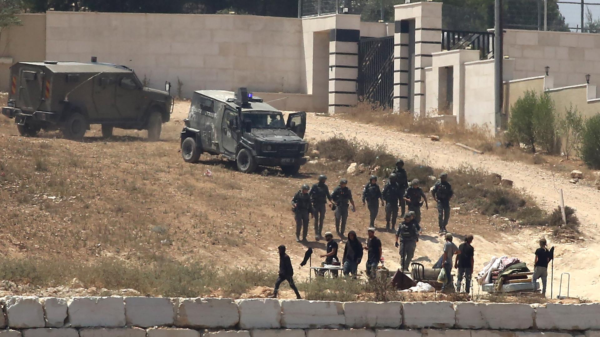 Israelische Soldaten stehen im besetzten Westjordanland im Dorf Kusra südlich von Nablus neben Siedlern Wache vor palästinensischen Häusern, die sie abgeriegelt haben. Israelische Soldaten stehen im besetzten Westjordanland im Dorf Kusra südlich von Nablus neben Siedlern Wache vor palästinensischen Häusern, die sie abgeriegelt haben.