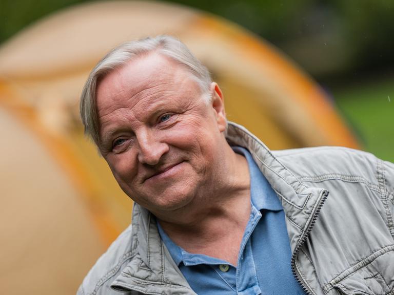 Schauspieler Axel Prahl steht als Hauptkommissar Frank Thiel am Set vom Münster "Tatort" zwischen Zelten im Park hinter dem Schloss. 