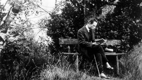 Der Schriftsteller Rainer Maria Rilke lesend auf einer Parkbank in Rippoldsau im Schwarzwald, ca. 1913.