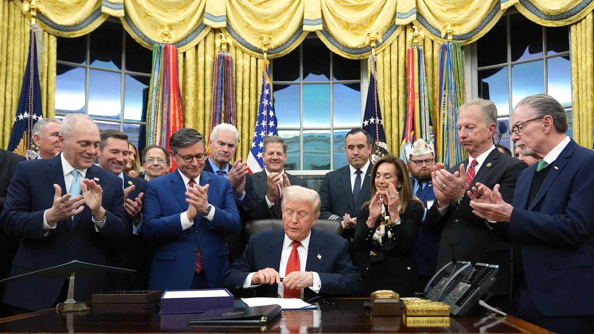 Präsident Donald Trump unterzeichnet im Oval Office des Weißen Hauses in Washington das Gesetz zur Wiederaufnahme der Regierungsgeschäfte. Er wird dabei umringt von Personen. Präsident Donald Trump unterzeichnet im Oval Office des Weißen Hauses in Washington das Gesetz zur Wiederaufnahme der Regierungsgeschäfte. Er wird dabei umringt von Personen.