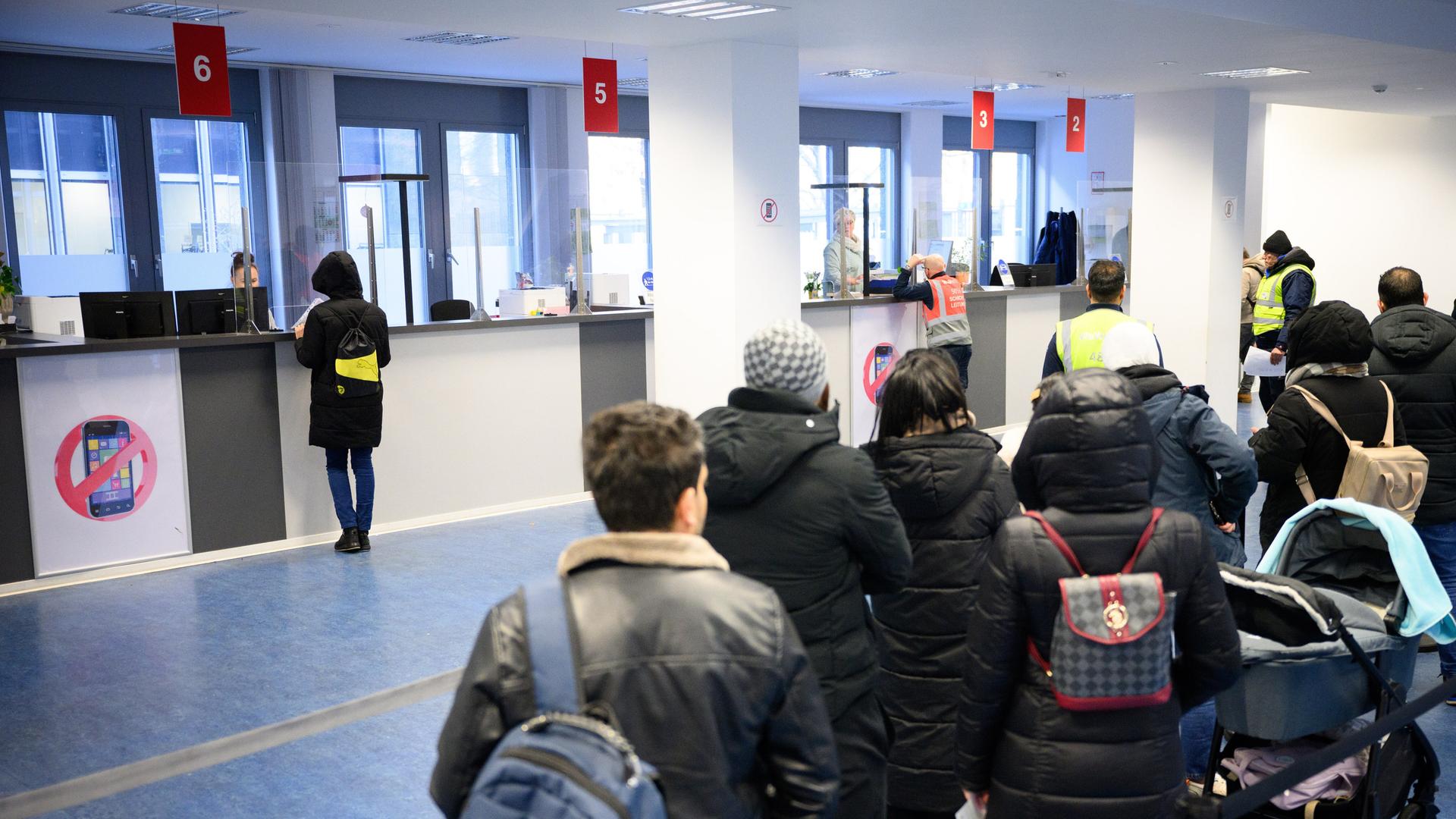 Besucher warten vor Informationsschaltern im Landesamt für Flüchtlingsangelegenheiten (LAF) in Berlin-Charlottenburg.