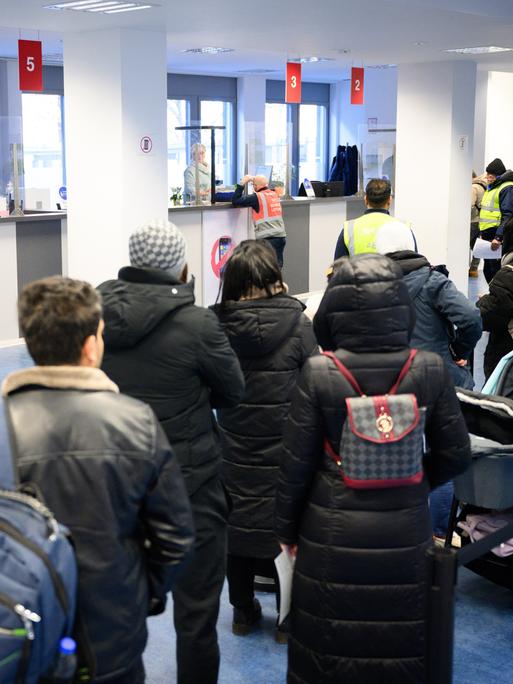 Besucher warten vor Informationsschaltern im Landesamt für Flüchtlingsangelegenheiten (LAF) in Berlin-Charlottenburg.