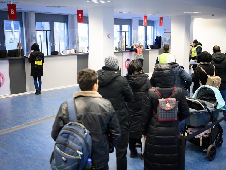 Besucher warten vor Informationsschaltern im Landesamt für Flüchtlingsangelegenheiten (LAF) in Berlin-Charlottenburg.