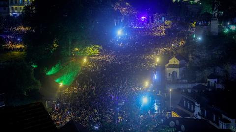 Zu sehen ist eine große Menschenmenge in Georgiens Hauptstadt Tiflis im abendlichen Dunkel. 